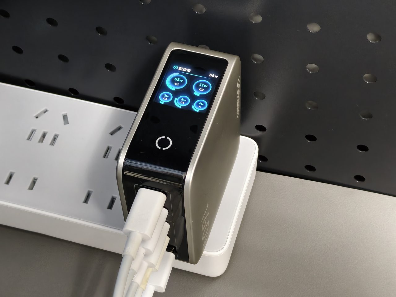 A wall charger reporting its live output on a small built-in display
