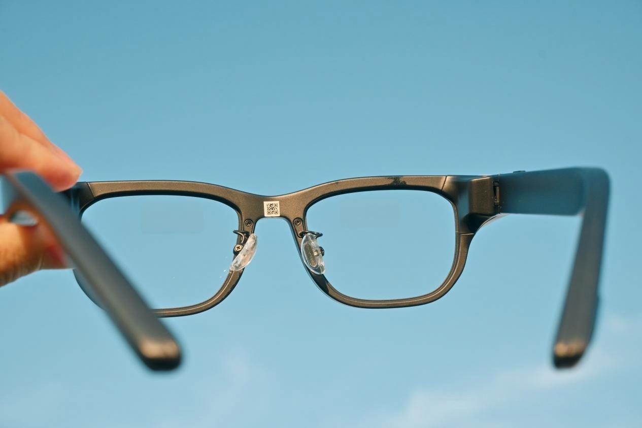A pair of lightweight smart glasses held in one hand