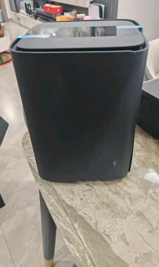 A NAS appliance with a fabric-wrapped front panel standing on a table indoors