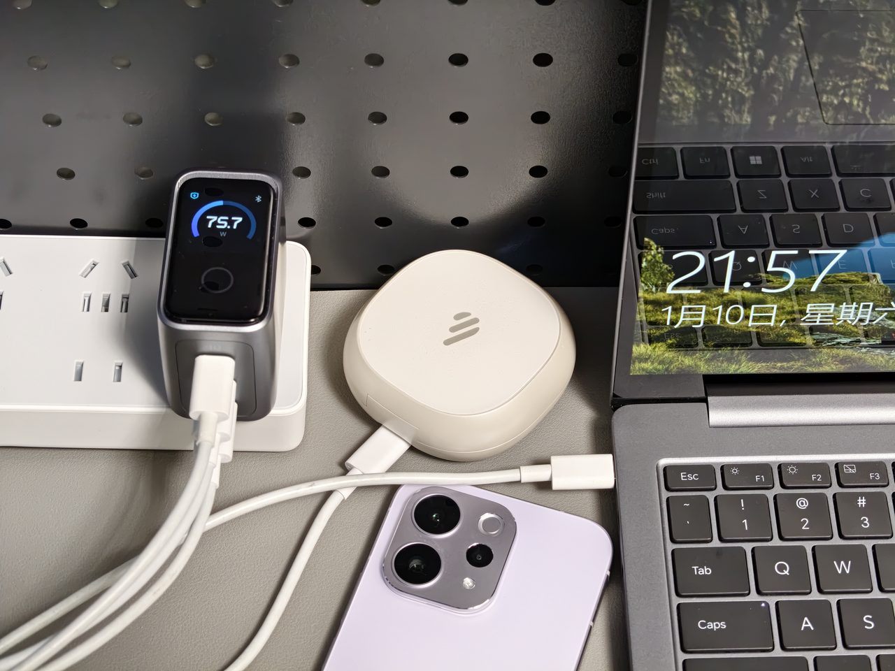 One charger serving a laptop, a phone and a small accessory at the same time on a desk
