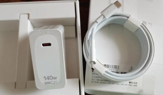 A 140W charger photographed with its retail packaging